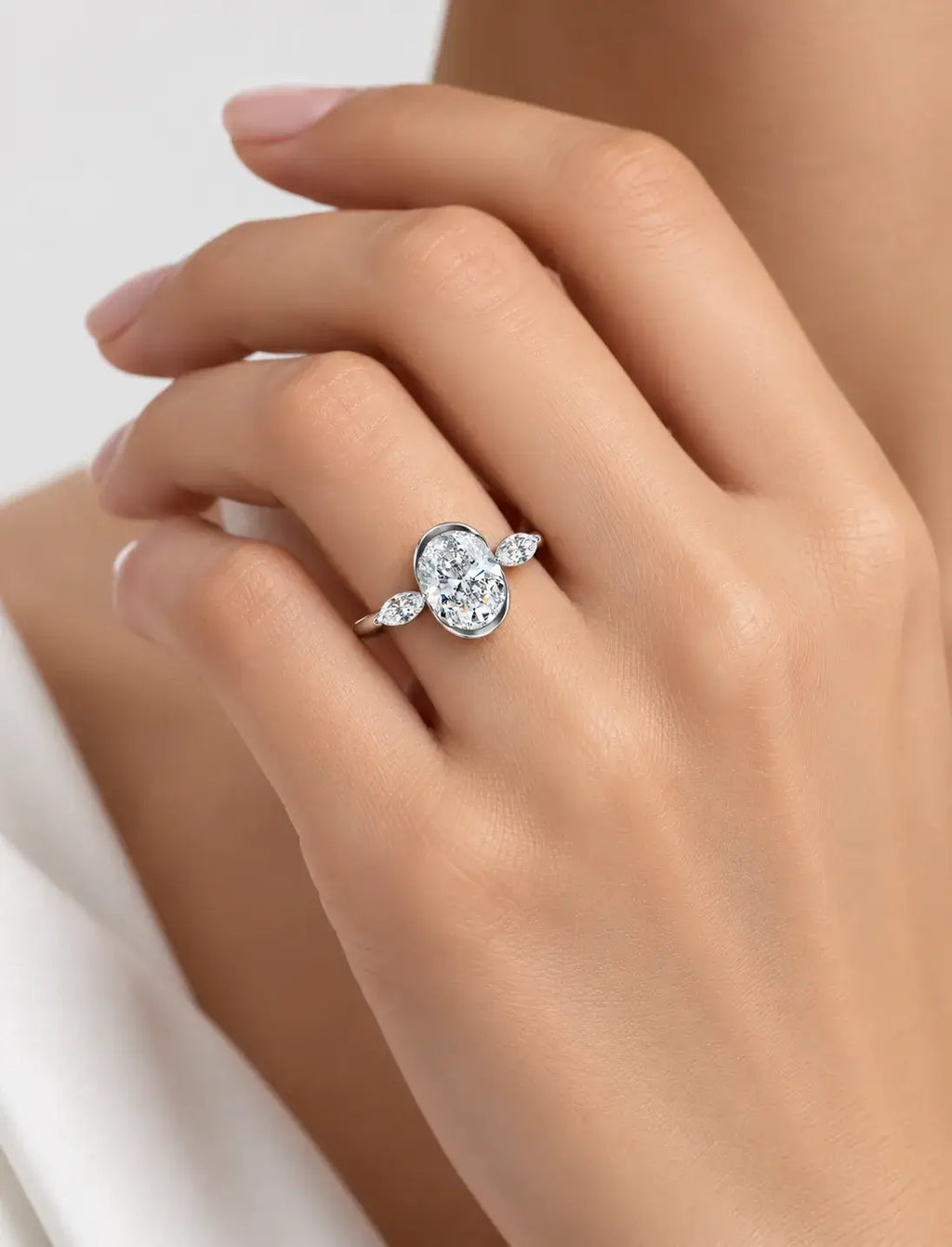 IGI Certified Lab Grown Oval Bezel Three-Stone Diamond Engagement Ring with Marquise Accents in Gold & Platinum