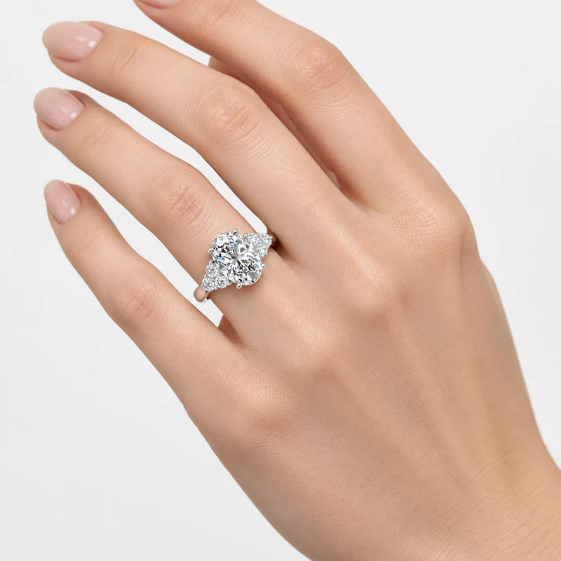 Oval-Cut Diamond Engagement Ring with Cluster Side Stones in Gold & Platinum