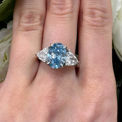 6.05 Carat IGI Lab Fancy Vivid Blue Oval & Side Trillion Diamond Three-Stone Ring In Platinum